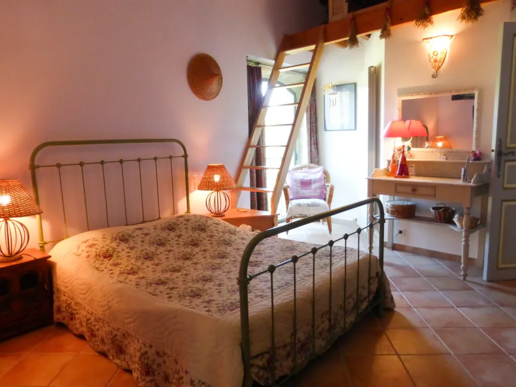 Chambre Lavande du Domaine du Coffre à Pertuis - chambre double avec mezzanine et terrasse ombragée Chambre Lavande du Domaine du Coffre avec lit en fer forgé, mezzanine et ambiance douce