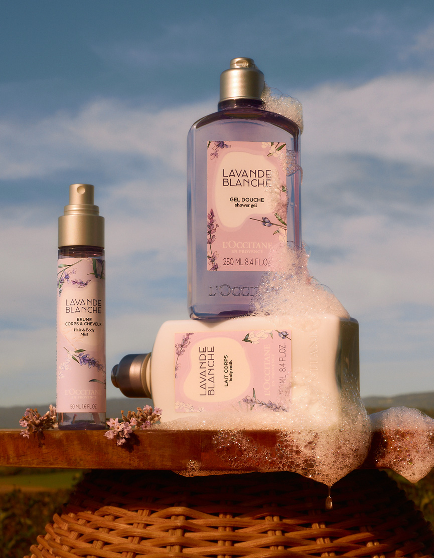 Produits de la gamme Lavande Blanche de L’OCCITANE en Provence posés sur une corbeille en osier