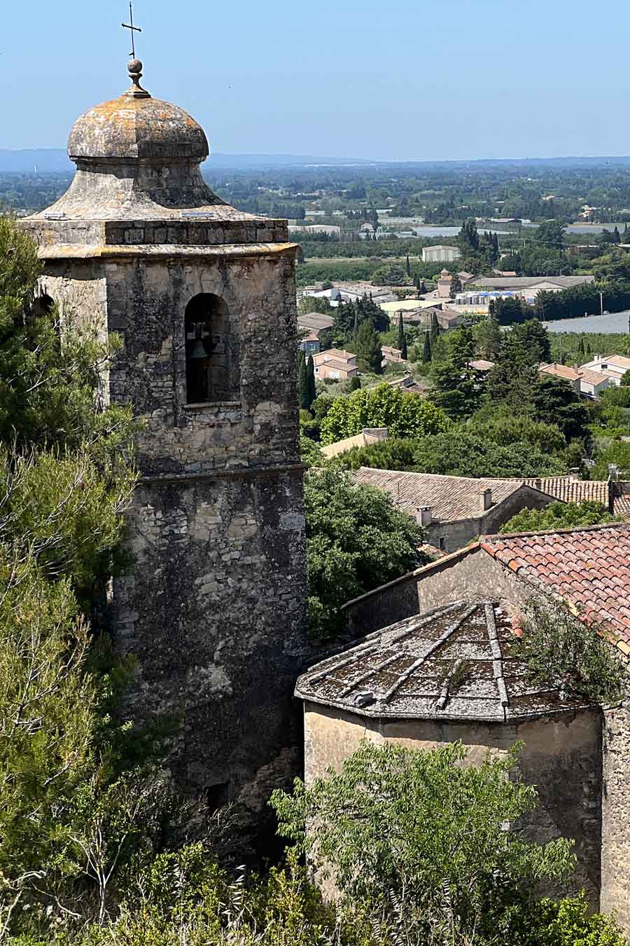 Vue sur le clocher du village de Lagnes et la vallée environnante Vue sur le clocher et les toits du vieux village de Lagnes avec la plaine en arrière-plan