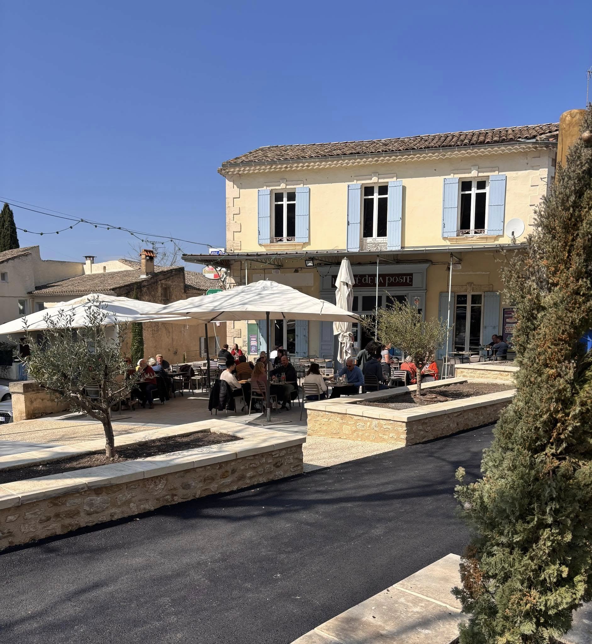 Terrasse du Café de la Poste à Robion, au cœur du Luberon Terrasse ensoleillée du Café de la Poste à Robion dans le Luberon