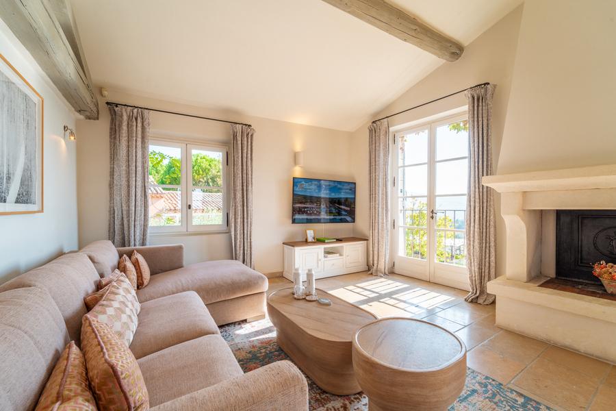 Salon lumineux d'une suite de Coquillade Provence avec cheminée et vue extérieure