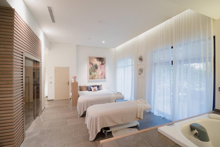 Cabine de soins du Spa Coquillade Provence avec tables de massage et lumière naturelle