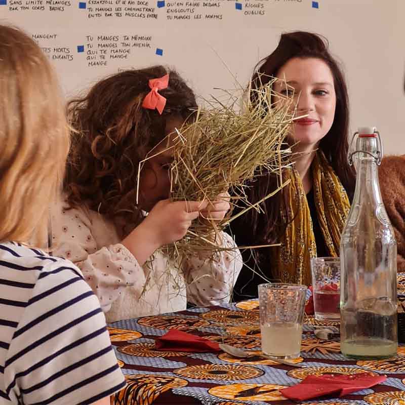 Moment partagé autour d’un repas lors du spectacle banquet Sur la paille, mêlant théâtre, cuisine et participation des habitants.