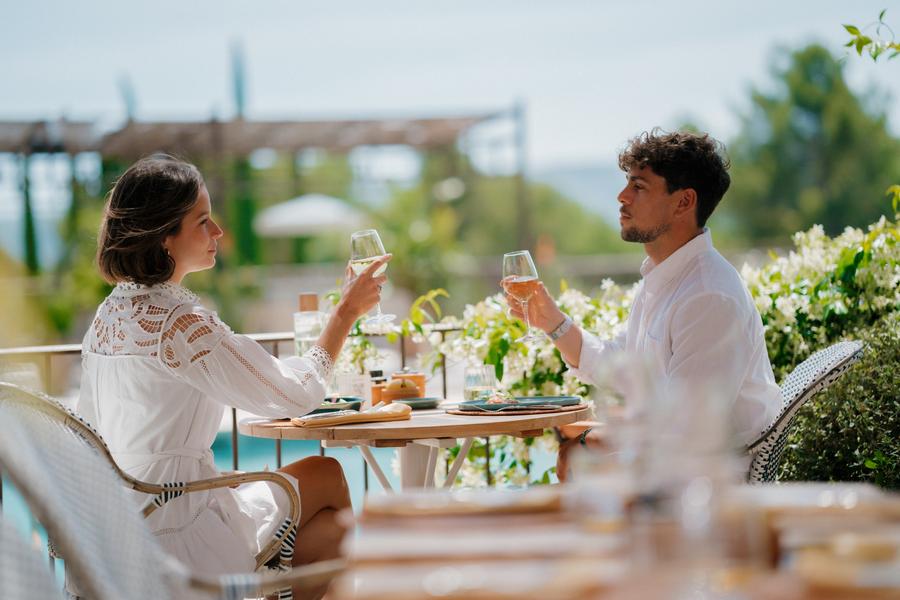 Couple déjeunant en terrasse au restaurant Cipressa à Coquillade Provence, avec vue sur le Luberon