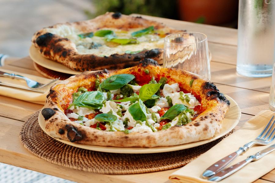 Pizza napolitaine au feu de bois garnie de mozzarella et basilic, servie au restaurant Cipressa à Coquillade Provence