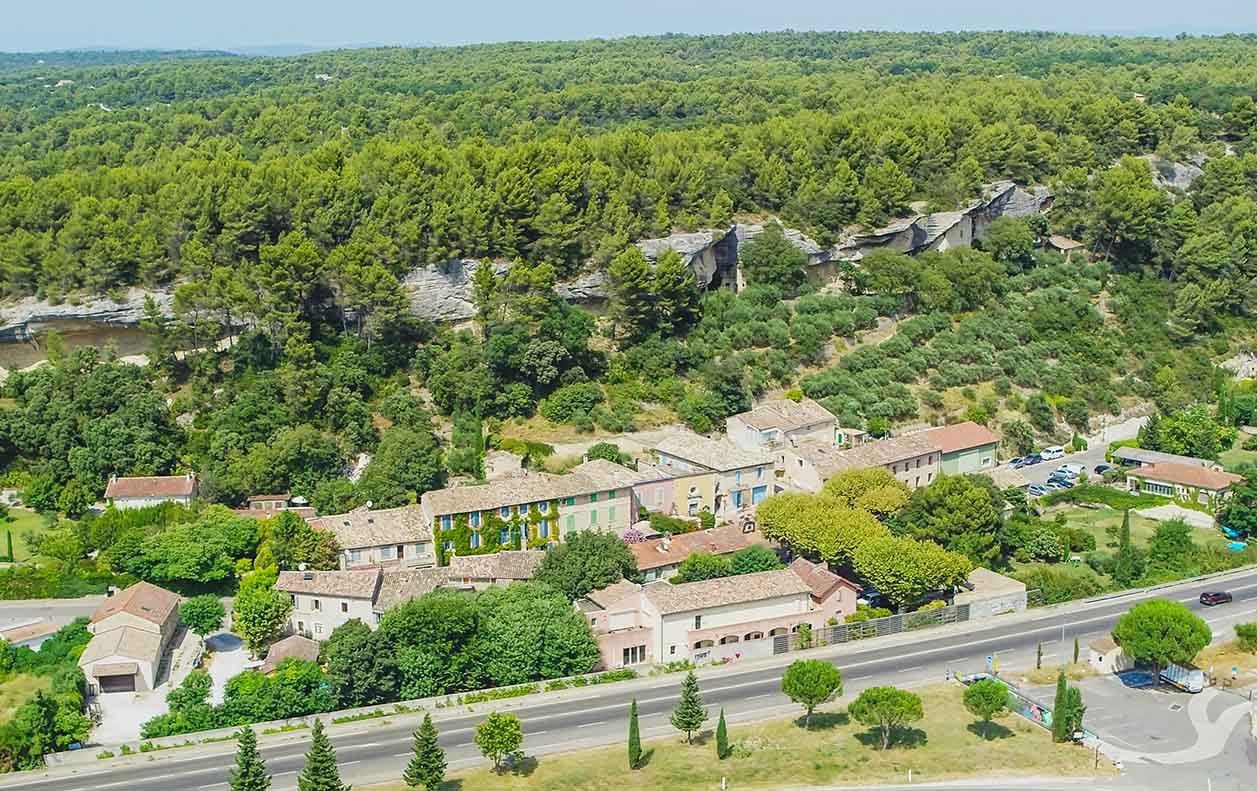 Vue aérienne du village des Beaumettes et de ses maisons troglodytiques au pied de la colline, dans le Luberon