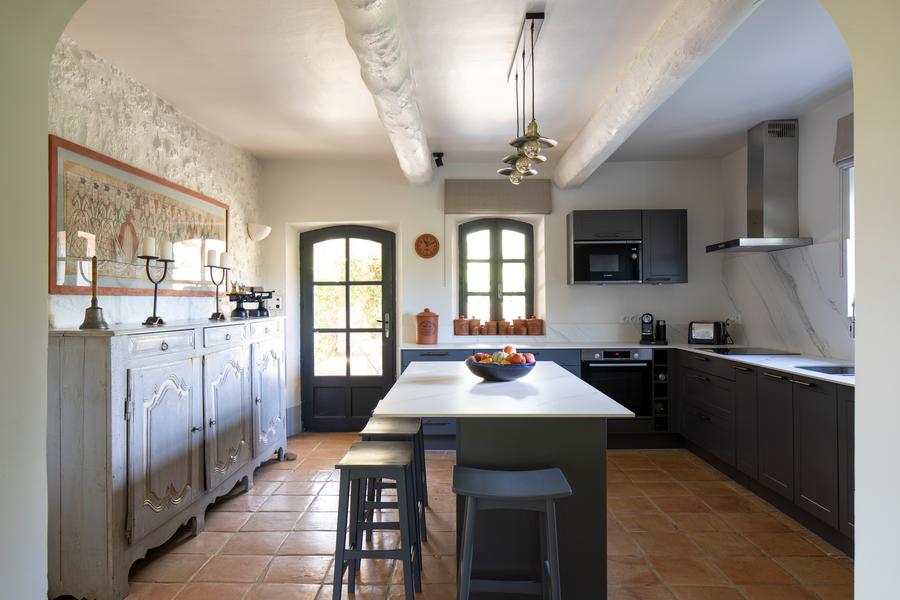 Cuisine équipée du Mas Petit Collongue à Lourmarin Cuisine moderne et lumineuse du Mas Petit Collongue avec îlot central et accès terrasse