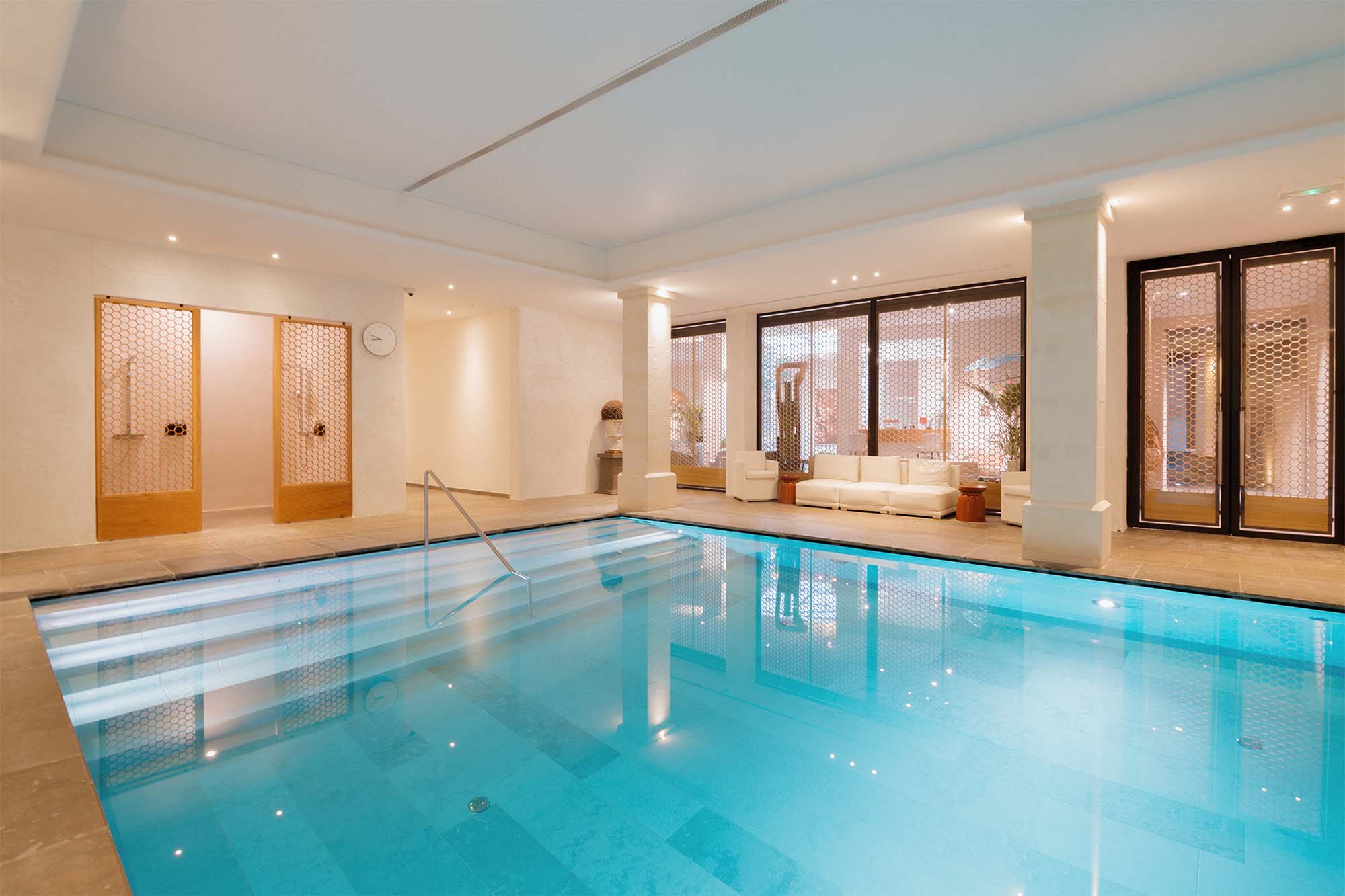 Piscine intérieure chauffée et luxueuse du Spa Coquillade Provence, parfaite pour se ressourcer à l'abri de la pluie