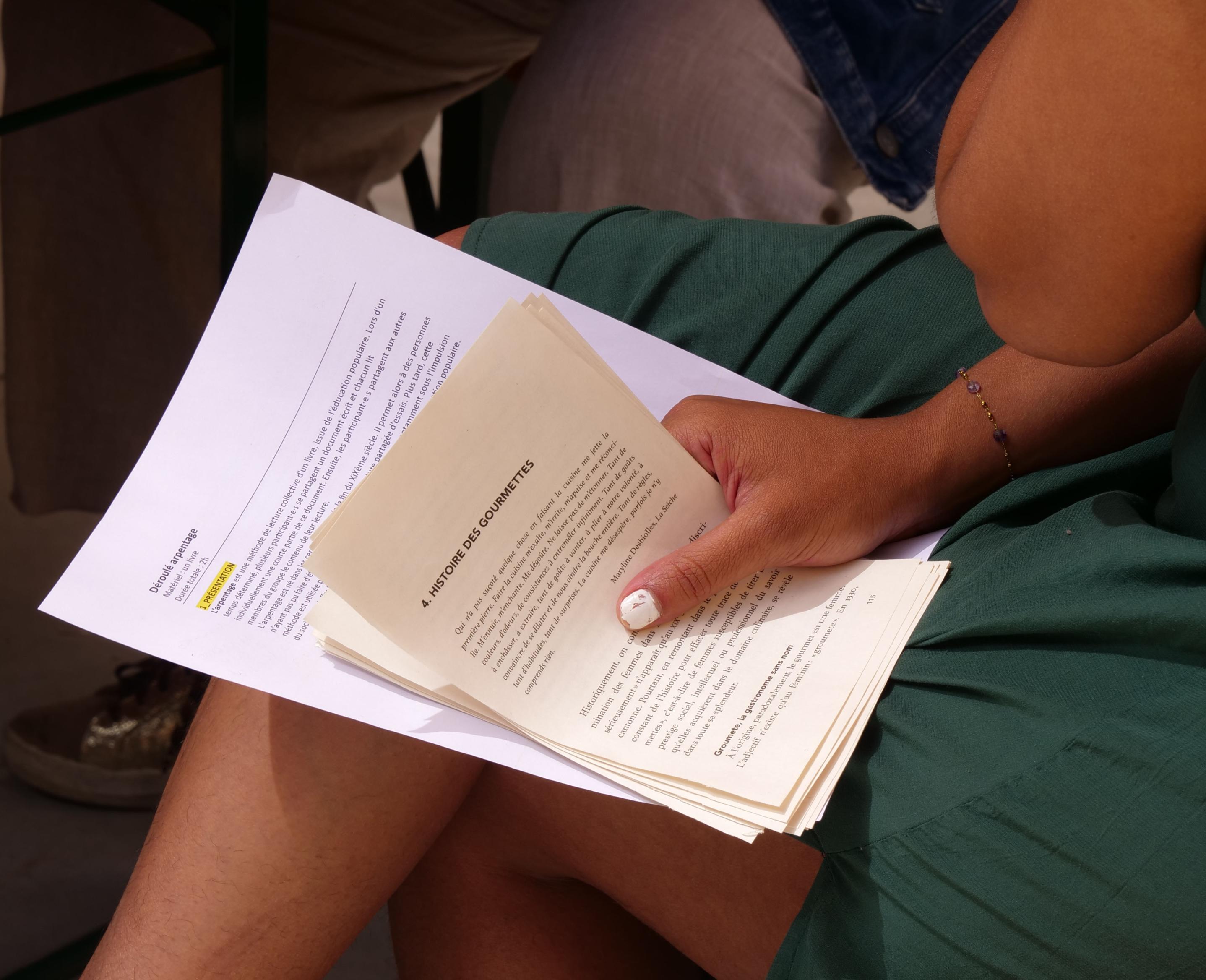 Participant feuilletant un livre lors d’un atelier de lecture collective et participative autour de l’alimentation au Festival Confit !