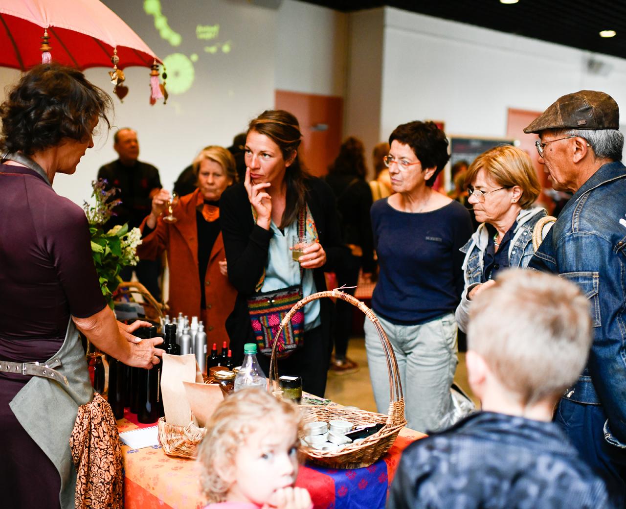 Visiteurs découvrant des produits locaux et échangeant avec des producteurs lors d’un marché convivial au Festival Confit !