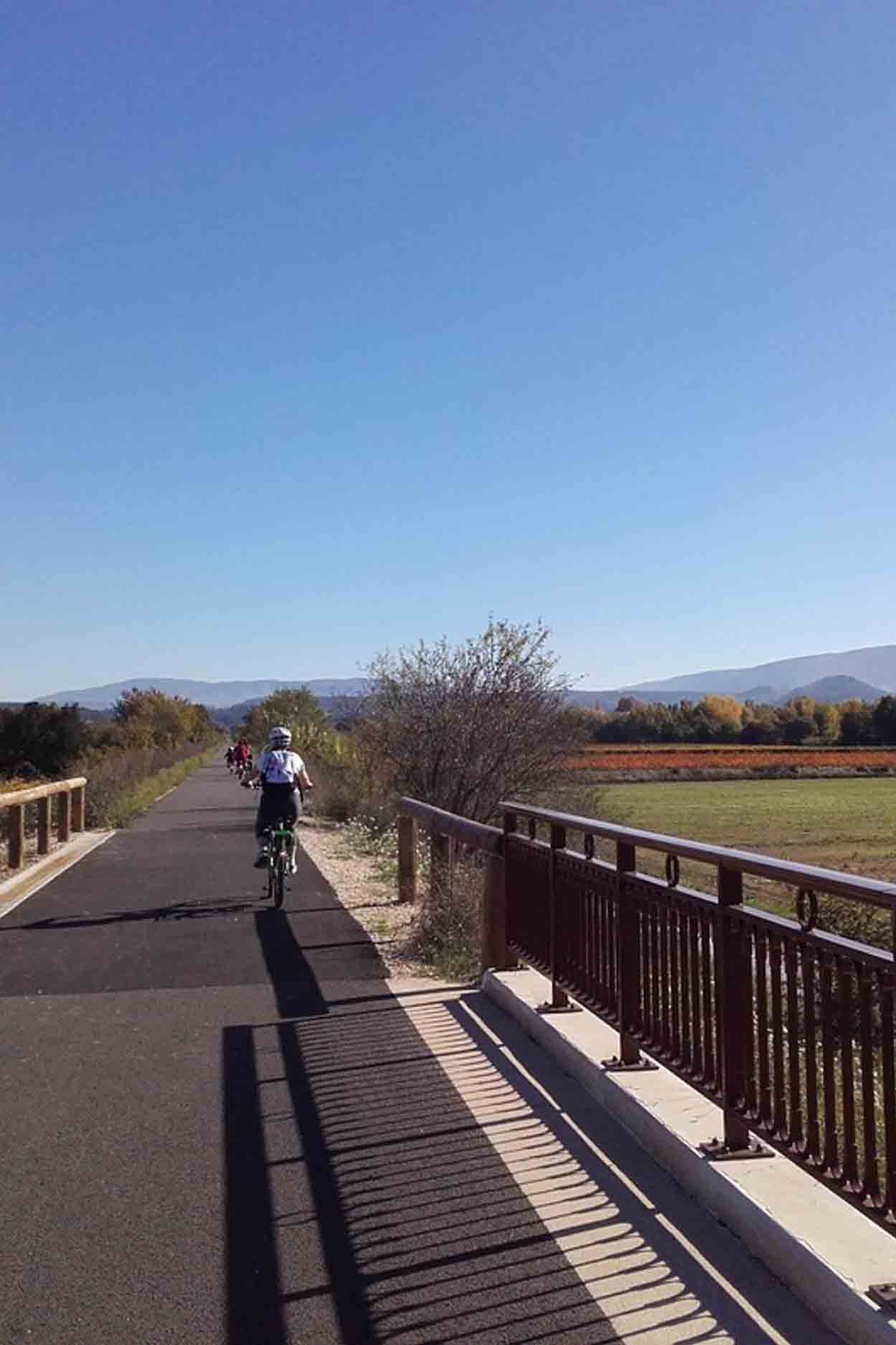 Cyclistes sur la véloroute du Calavon, au cœur des paysages du Petit Luberon, près de Ménerbes