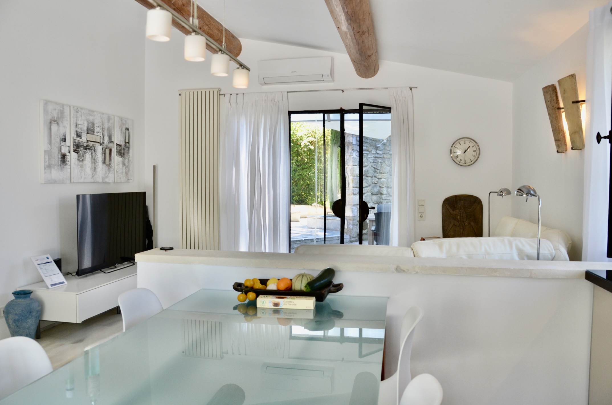 Salon et cuisine contemporaine – maison de charme Les Oliviers à Oppède Salon lumineux avec canapé contemporain et cuisine ouverte entièrement équipée dans la maison Les Oliviers à Oppède, en Luberon