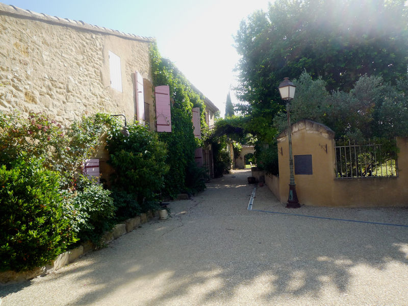 Entrée du Mas des 2 Fontaines à Cavaillon avec façade en pierre et végétation méditerranéenne