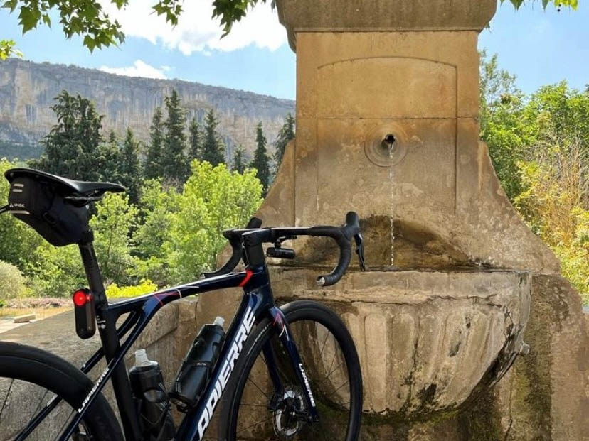 Pause à vélo dans le Luberon, entre patrimoine et paysages naturels Pause à vélo sur les routes du Luberon, près d’une fontaine au pied des paysages provençaux