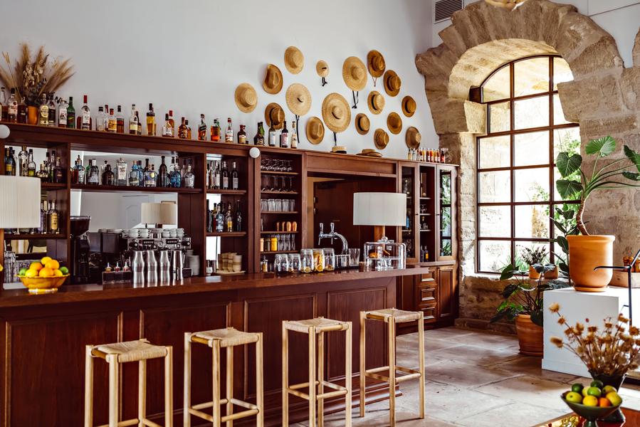 Le bar du Moulin à Lourmarin Le bar du Moulin à Lourmarin, comptoir et étagères de spiritueux dans un décor provençal