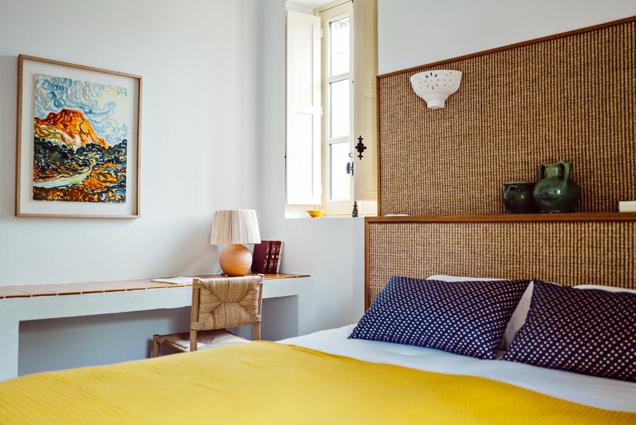 Détail chambre au Moulin à Lourmarin Détail d’une chambre au Moulin à Lourmarin, tête de lit en fibres naturelles et literie confortable