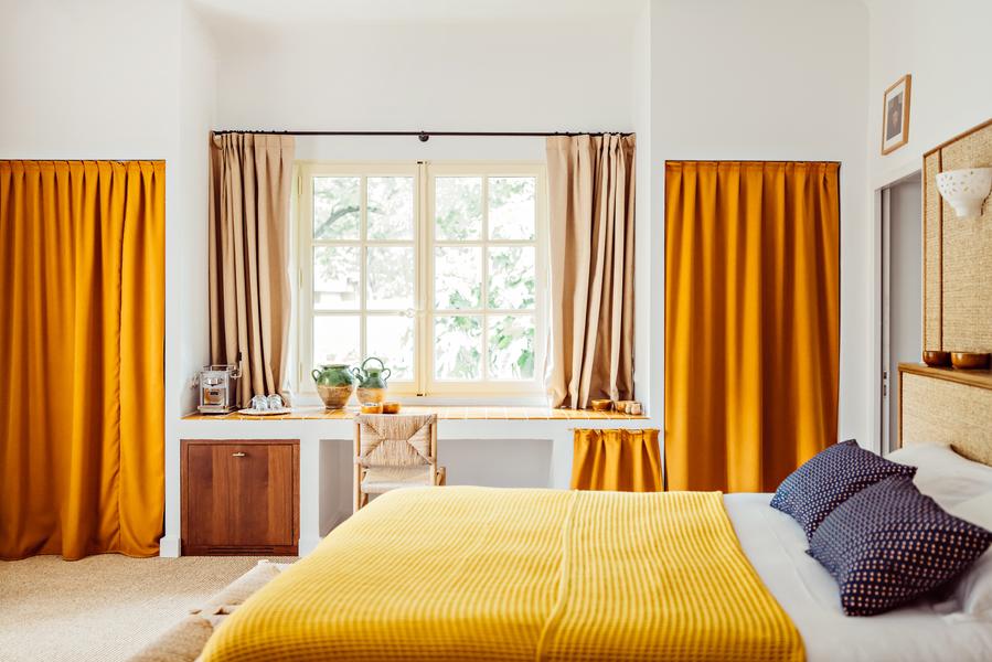 Chambre au Moulin à Lourmarin Chambre au Moulin, hôtel 4 étoiles à Lourmarin, avec lit double, linge jaune et rideaux ocres