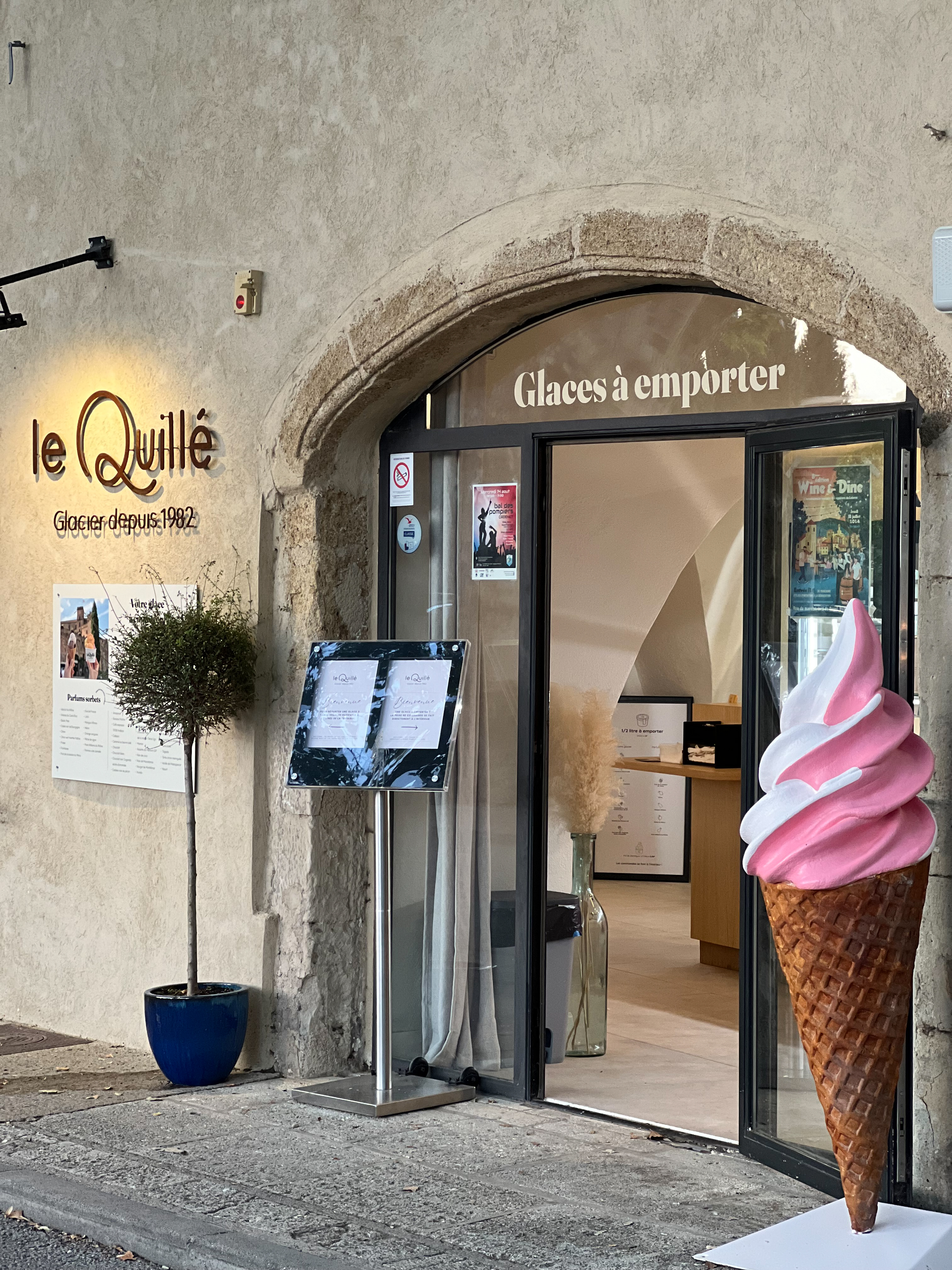 Le Quillé, glacier artisanal emblématique de Lourmarin depuis 1982 Façade du glacier Le Quillé à Lourmarin avec enseigne et cornet géant
