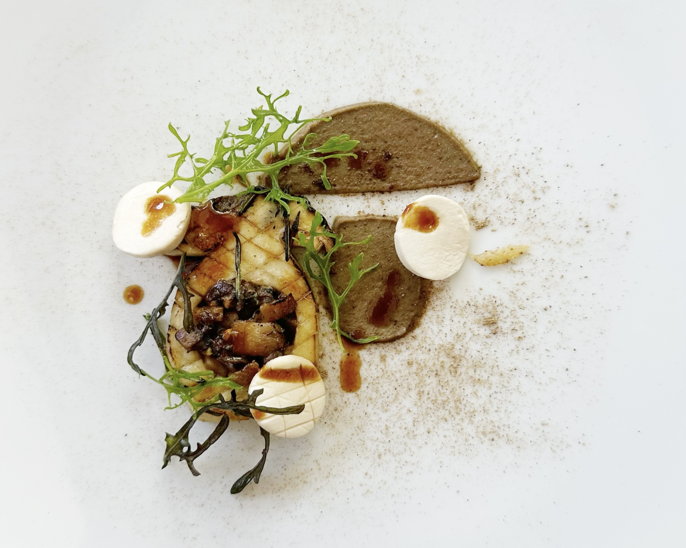 Création culinaire élaborée du restaurant L'Olivier, associant champignons, purée et herbes fraîches dans une présentation artistique.